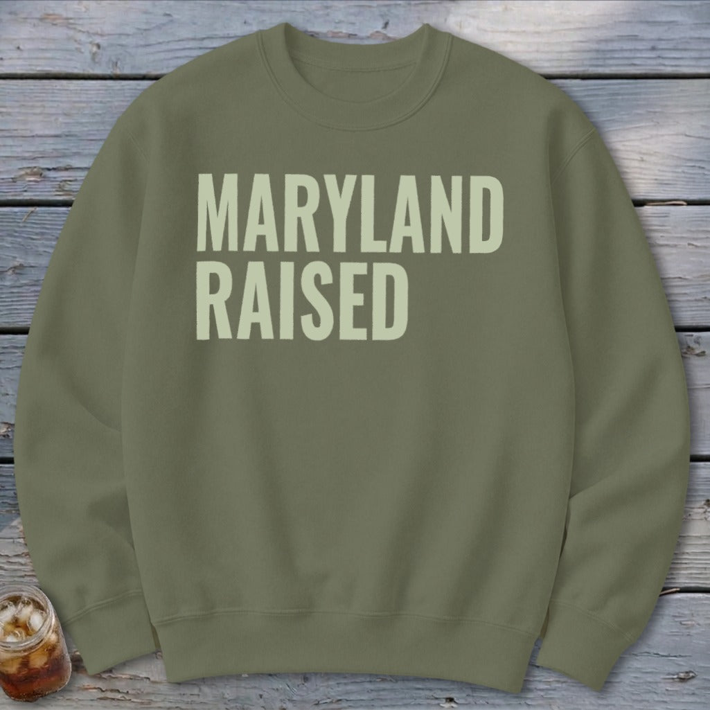 Olive green sweatshirt with cream text "MARYLAND RAISED"