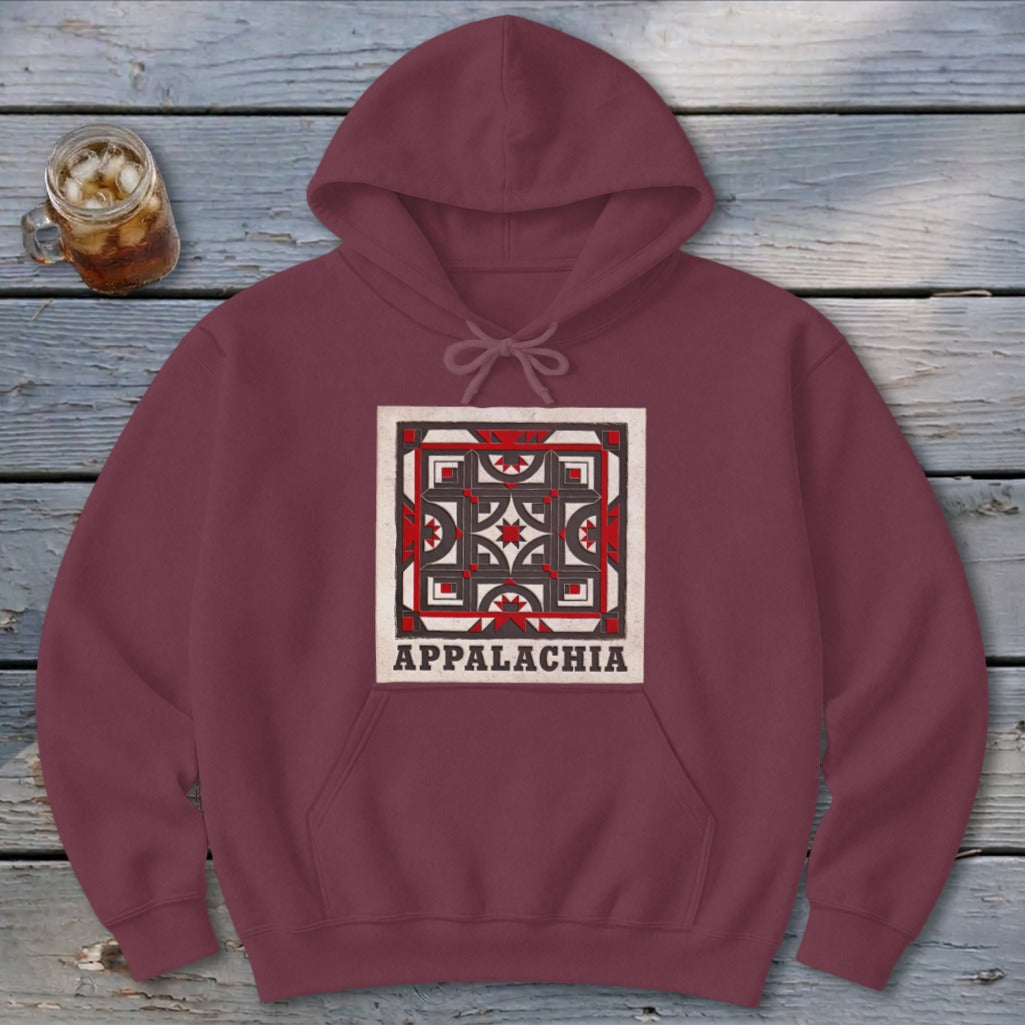 Maroon hoodie featuring a square geometric quilt pattern and the text Appalachia on a wooden background.