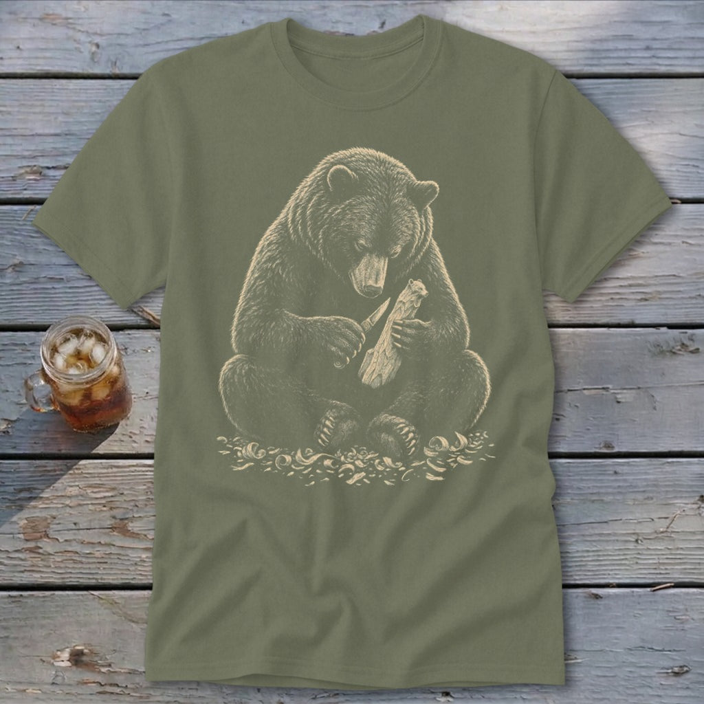 Bear carving wood with a knife on a khaki t-shirt.