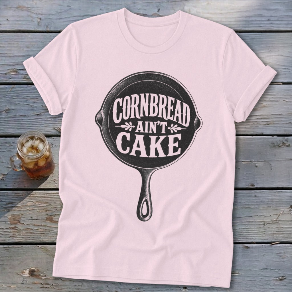 Pink t-shirt with "Cornbread Ain't Cake" text inside a cast iron skillet graphic.