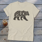 A cream-colored t-shirt with a dark brown graphic of a walking bear containing the text Appalachia.