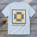 Light blue t-shirt with a square quilt block design reading "CHURN DASH".