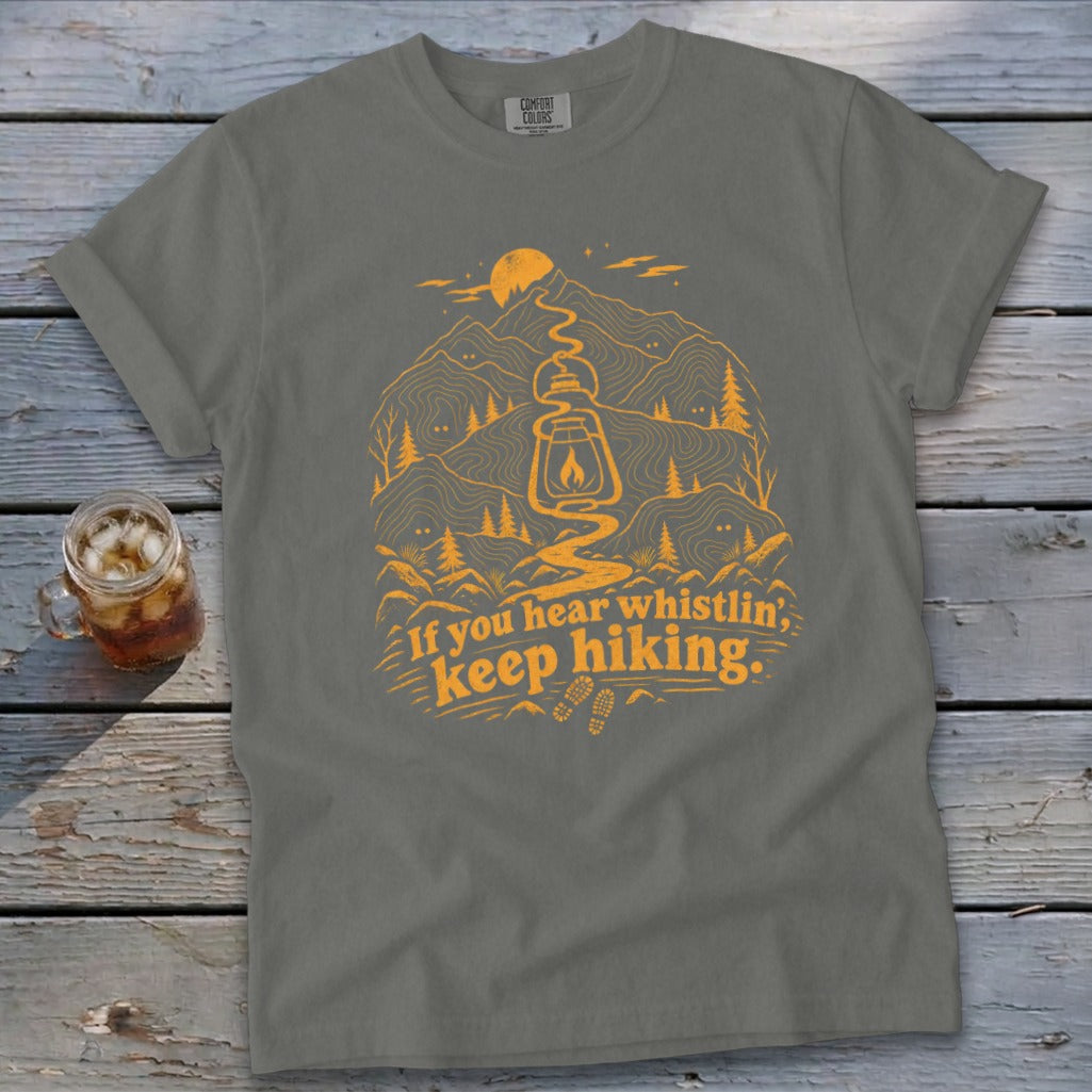 Gray t-shirt with orange hiking graphic and text "If you hear whistlin', keep hiking."