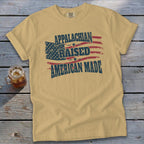 Appalachian Raised American Made text on a tan t-shirt with American flag graphic.