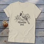 Cream t-shirt with black sketch of a cardinal perched on a branch with flowers and text "Mountain Soul".