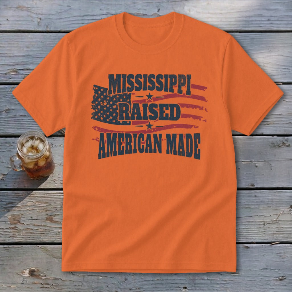 An orange t-shirt featuring the text Mississippi Raised American Made and a distressed American flag graphic.