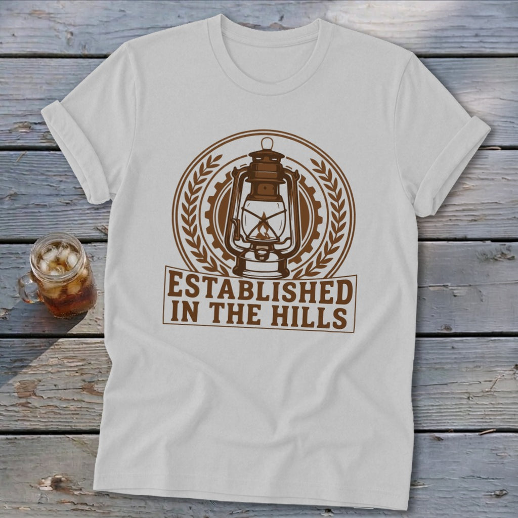White t-shirt with brown lantern graphic and text "Established in the Hills".
