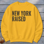 Yellow sweatshirt with "New York Raised" text in dark gray.