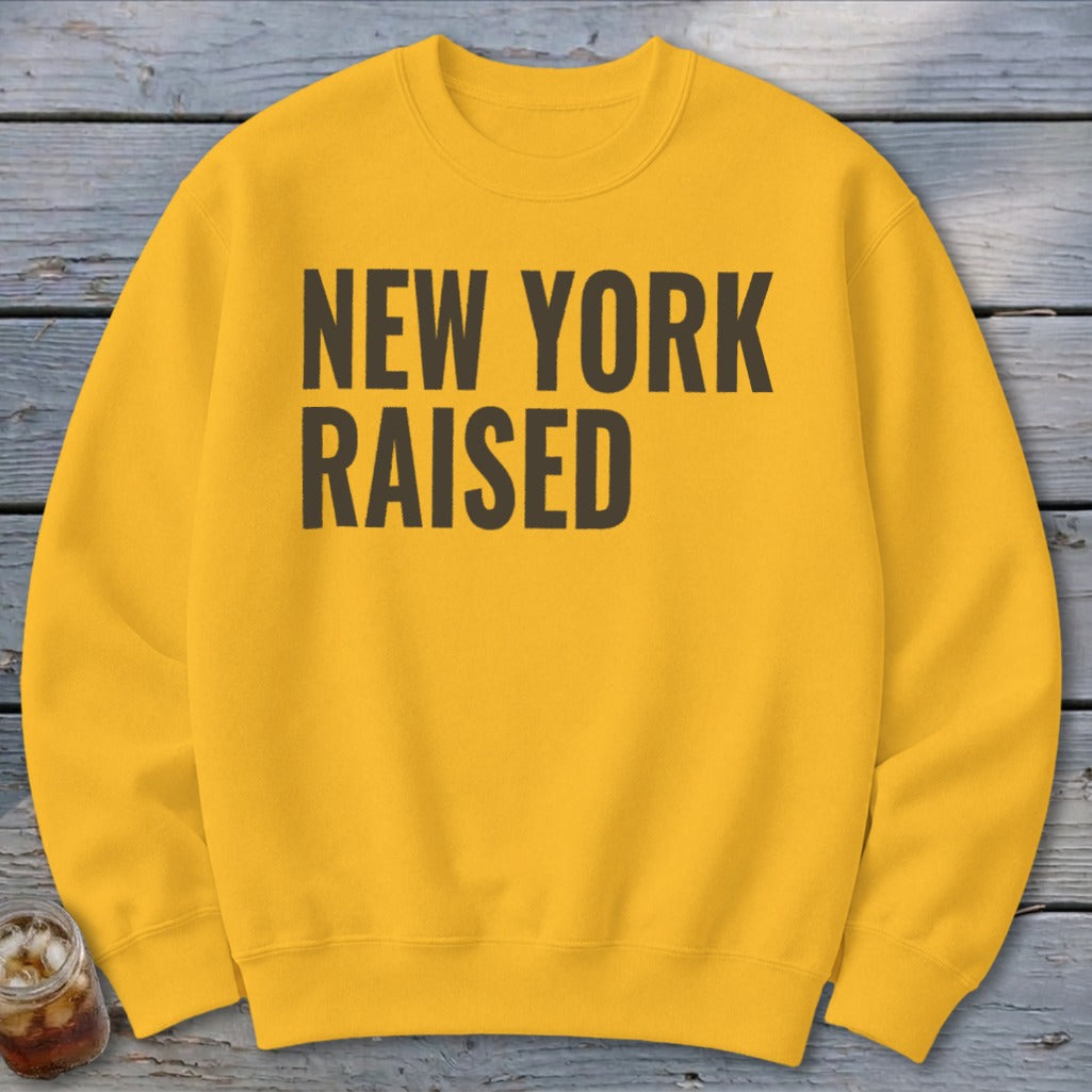 Yellow sweatshirt with "New York Raised" text in dark gray.