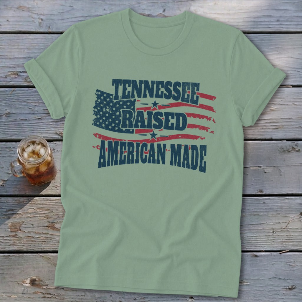 Light green t-shirt with "Tennessee Raised American Made" text over a distressed American flag graphic.