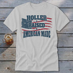 White t-shirt with "Holler Raised American Made" text and distressed American flag graphic.