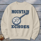Beige crewneck sweatshirt featuring a blue graphic of a banjo and the text "MOUNTAIN ECHOES".