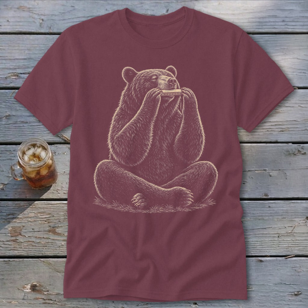 Bear sitting and playing a harmonica on a maroon t-shirt.