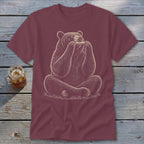 Bear sitting and playing a harmonica on a maroon t-shirt.