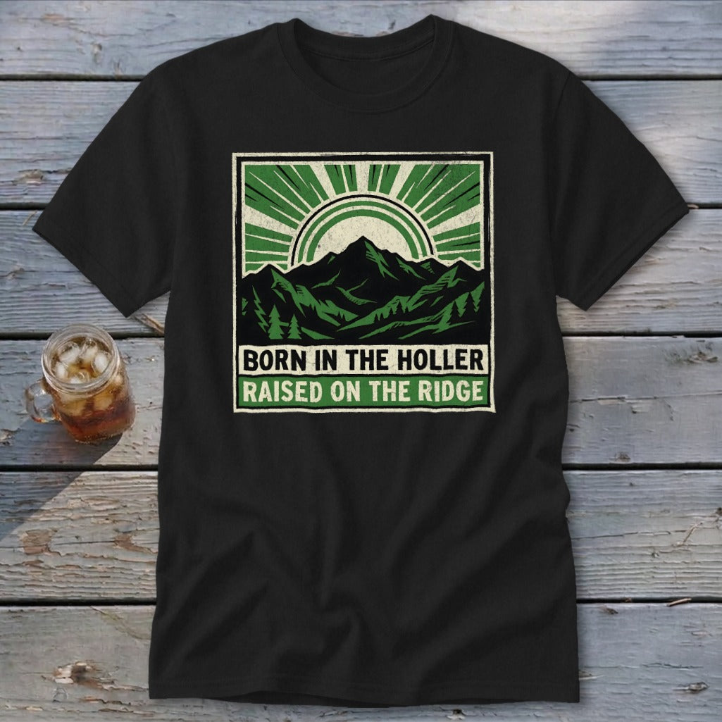 A black t-shirt featuring a green and cream graphic of mountains and sunburst rays with text.