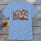 Light blue t-shirt featuring a stylized graphic of a mountain landscape designed as a patchwork quilt.