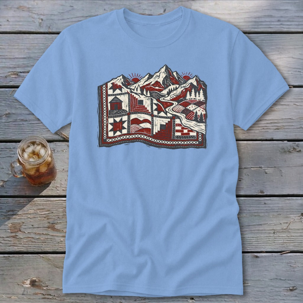 Light blue t-shirt featuring a stylized graphic of a mountain landscape designed as a patchwork quilt.