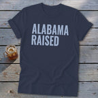 Dark blue t-shirt with "ALABAMA RAISED" in light gray text.