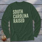 Dark green long-sleeve shirt with "SOUTH CAROLINA RAISED" in cream text.