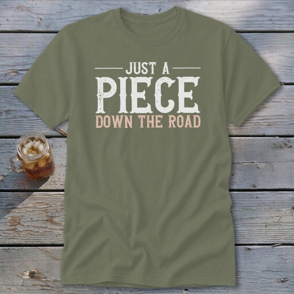 Olive green t-shirt with "JUST A PIECE DOWN THE ROAD" text.