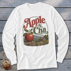 White long-sleeve t-shirt with a vintage graphic of a red apple on a wooden post before a mountain cabin.