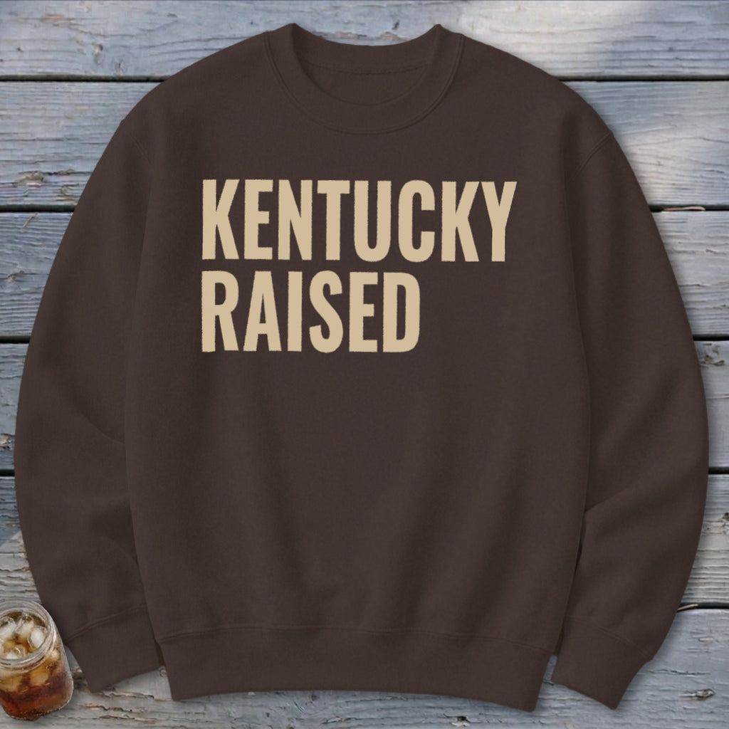 Brown crewneck sweatshirt with "KENTUCKY RAISED" printed in beige text.