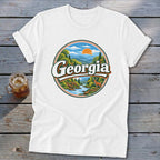White t-shirt with circular Georgia landscape graphic featuring mountains, river, and deer.