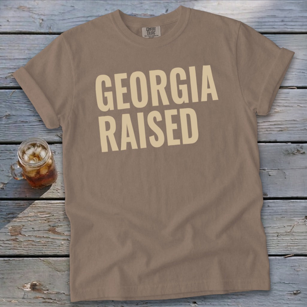 T-shirt with "GEORGIA RAISED" text in beige and a glass of iced tea.