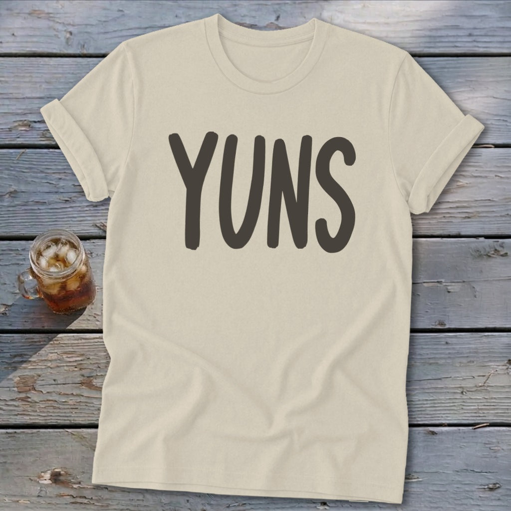 Cream t-shirt with "YUNS" in dark gray text and a glass of iced tea.