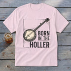 Light pink t-shirt with a banjo graphic and text "BORN IN THE HOLLER".