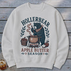 White sweatshirt with Hollerbear Apple Butter Season graphic featuring a bear stirring a pot.
