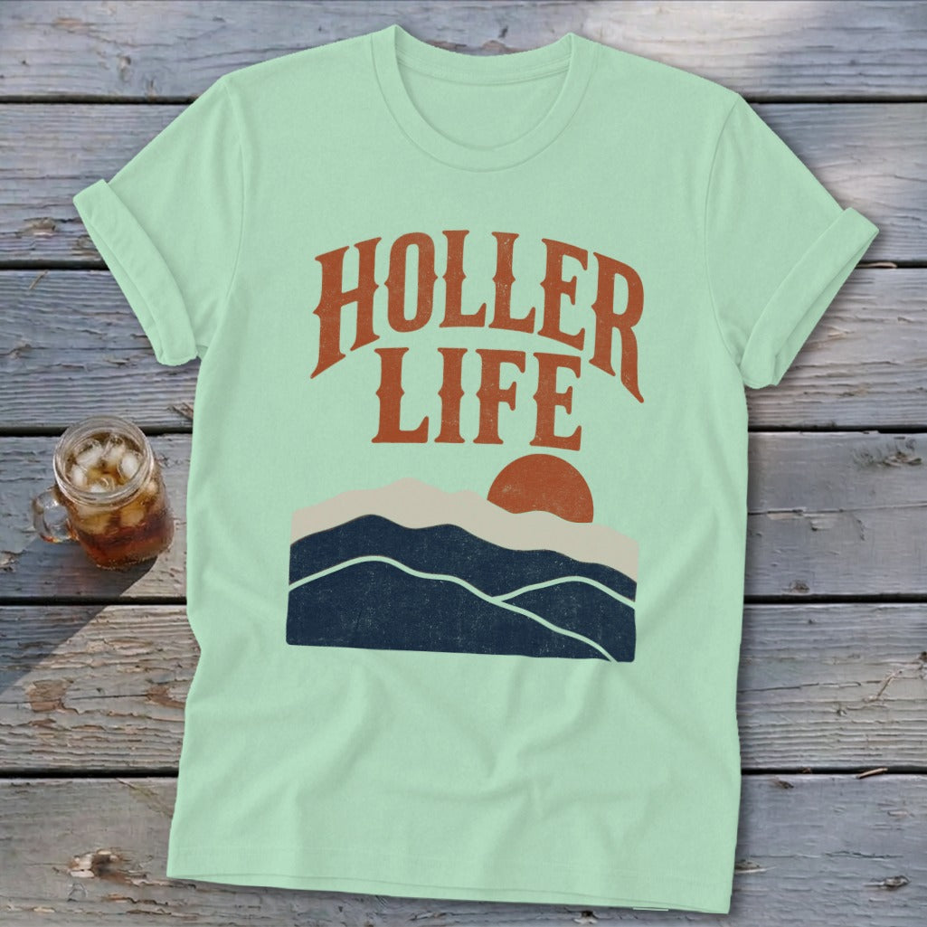 Light green crewneck t-shirt featuring a retro mountain landscape graphic with the text HOLLER LIFE.