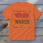 An orange crewneck t-shirt featuring a rusty sign graphic with red crossed-out text saying WASH and brown text saying WARSH with a green checkmark below it, laid flat on a rustic wooden background.