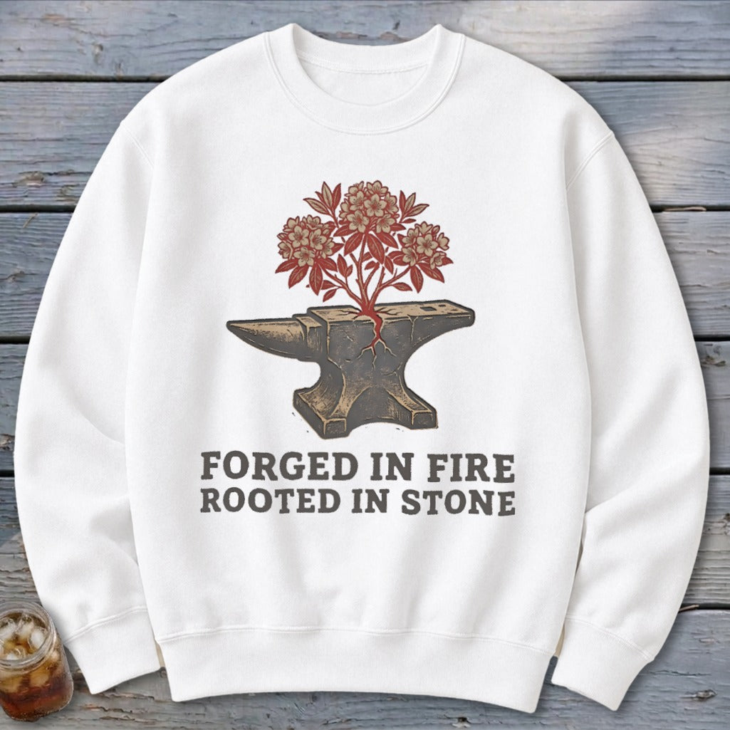 White sweatshirt with an anvil, a plant growing from it, and the text "FORGED IN FIRE ROOTED IN STONE".