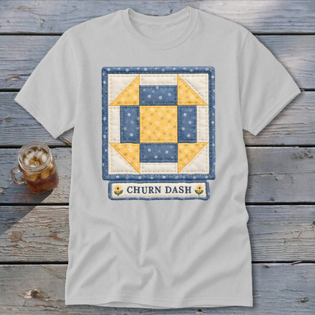 White t-shirt featuring a blue and yellow churn dash quilt block with "CHURN DASH" text.