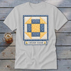 White t-shirt featuring a blue and yellow churn dash quilt block with "CHURN DASH" text.