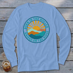 Light blue long-sleeve t-shirt with a round graphic reading Born in the Holler Raised on the Ridge with mountains and sun.