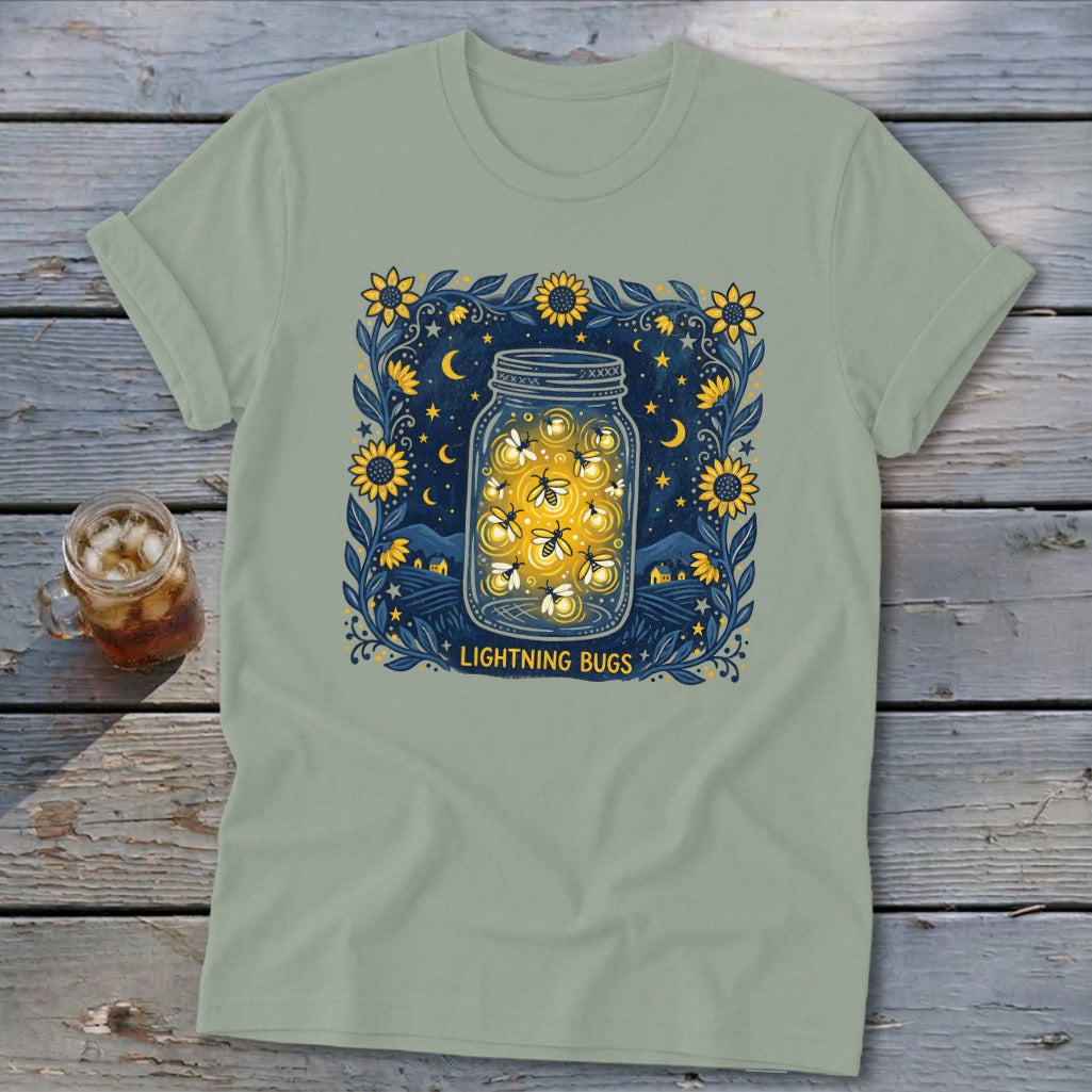 T-shirt with a mason jar filled with glowing lightning bugs, surrounded by sunflowers and night sky.