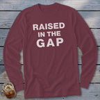 Maroon long-sleeve t-shirt with white text "RAISED IN THE GAP"