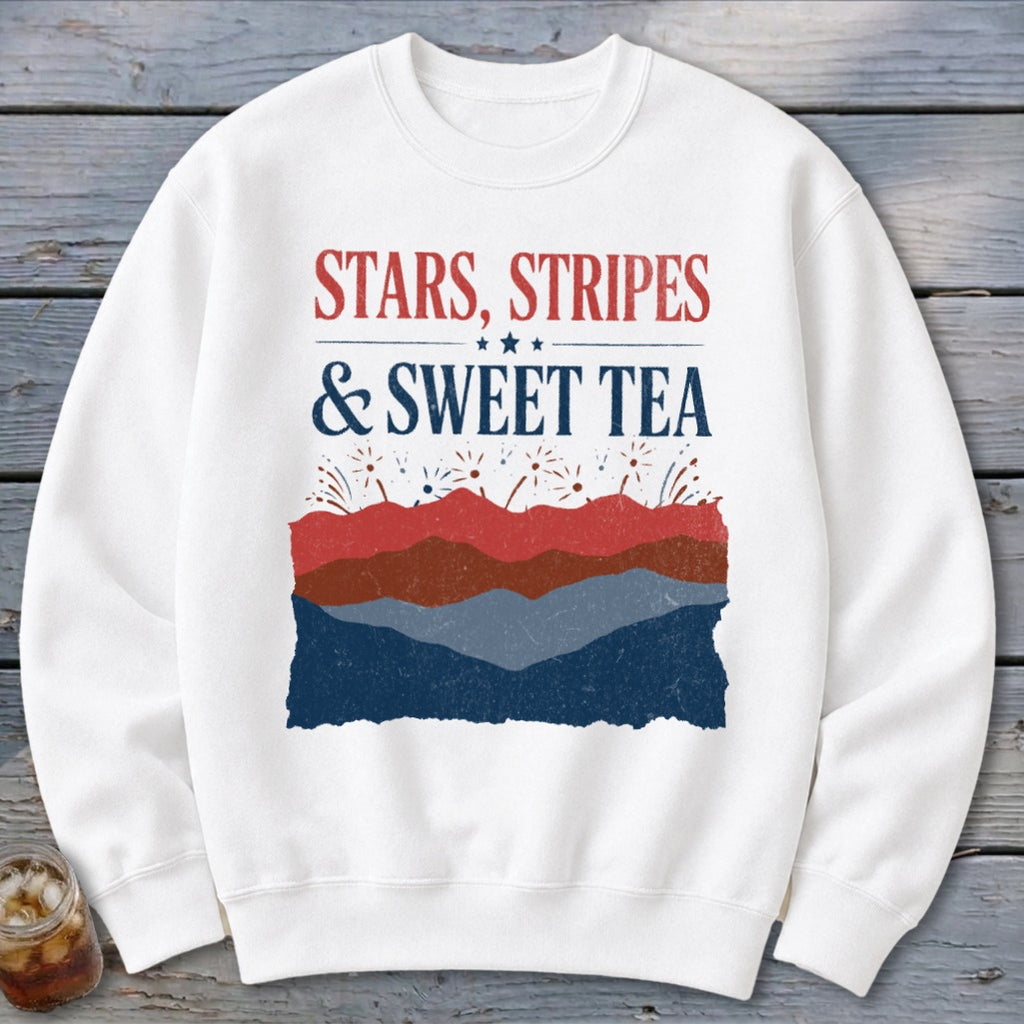 White crewneck sweatshirt featuring red and blue patriotic text and layered mountain graphics.