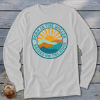 Light gray long-sleeve t-shirt featuring a circular graphic with mountains, a rising sun, and the text Born in the Holler Raised on the Ridge.