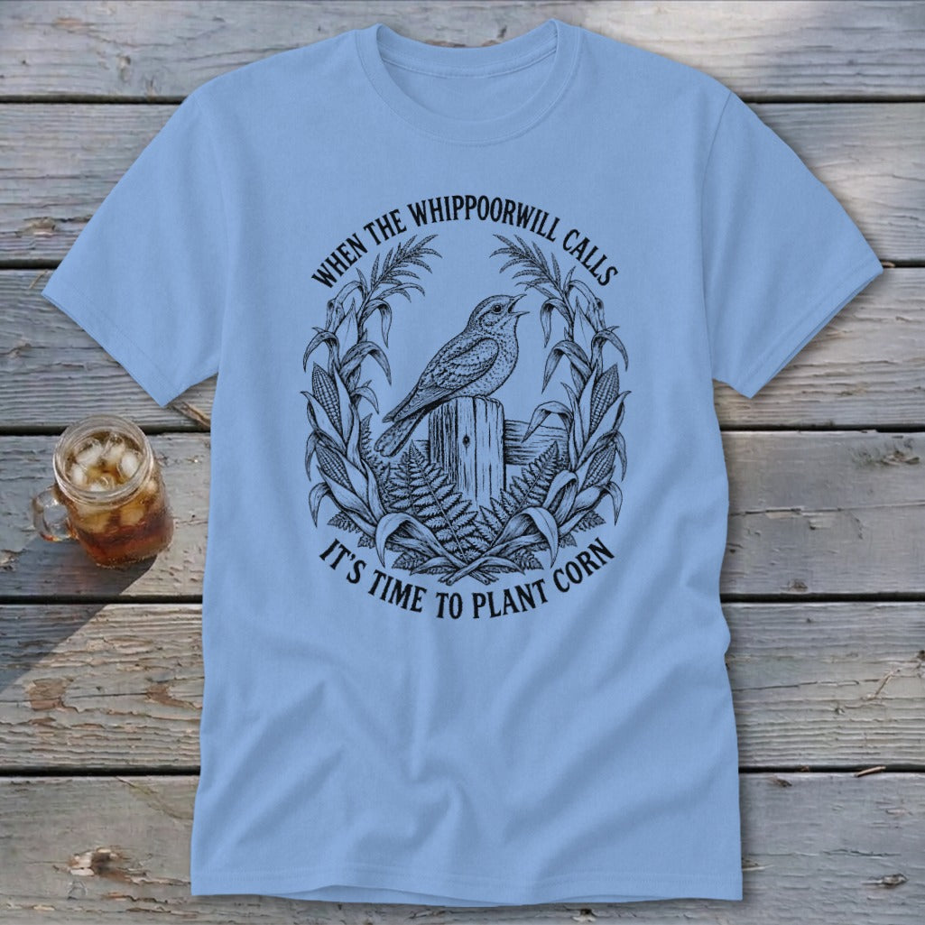 Light blue t-shirt featuring a black graphic of a bird on a post and corn stalks.