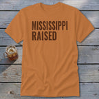 Orange t-shirt with dark brown text reading "MISSISSIPPI RAISED".