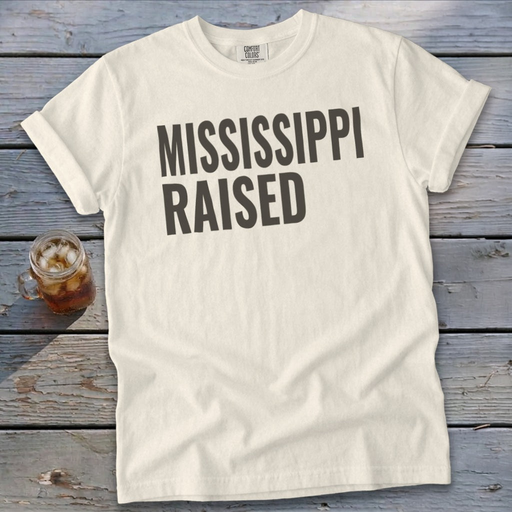 Cream t-shirt with "MISSISSIPPI RAISED" in dark gray text.
