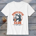 White v-neck t-shirt with a bear drinking from a jar, text "PORCH SITTIN' CLUB est. after supper".