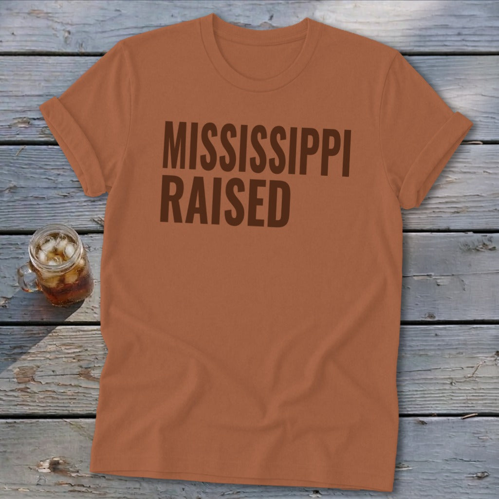 Orange t-shirt with brown text "MISSISSIPPI RAISED" and a glass of iced tea.
