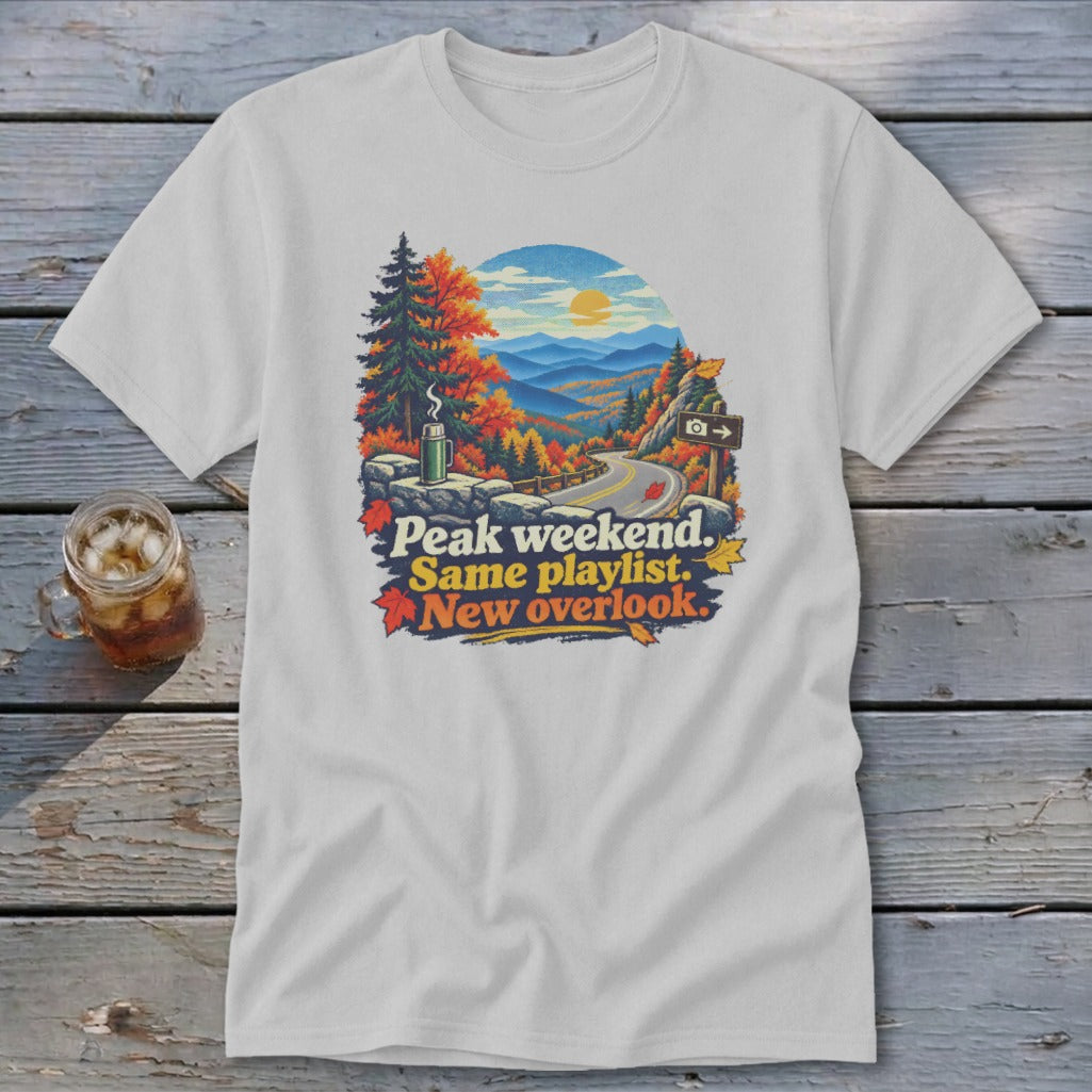 White t-shirt with "Peak weekend. Same playlist. New overlook." text and mountain scene.