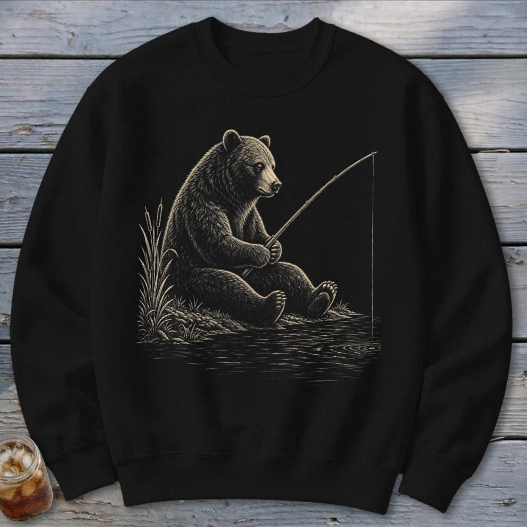 Black sweatshirt with distressed illustration of a bear fishing by reeds.