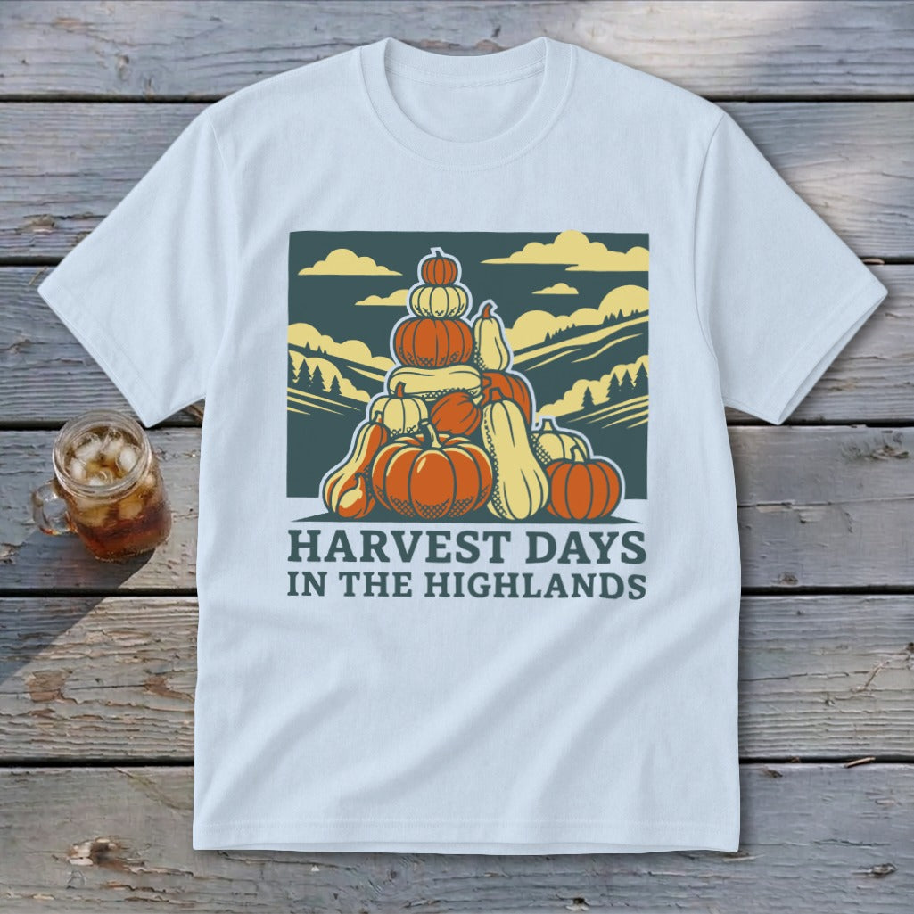 A light gray t-shirt featuring a graphic of stacked pumpkins, mountains, and the text Harvest Days in the Highlands.