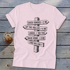 Light pink short-sleeved t-shirt with a black graphic of directional wooden signs on a rustic wooden background.